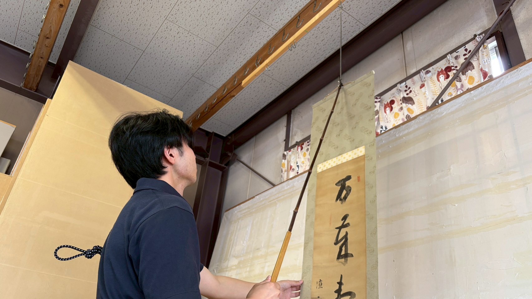 仕上がった掛軸を吊り下げ、全体のバランスを整える