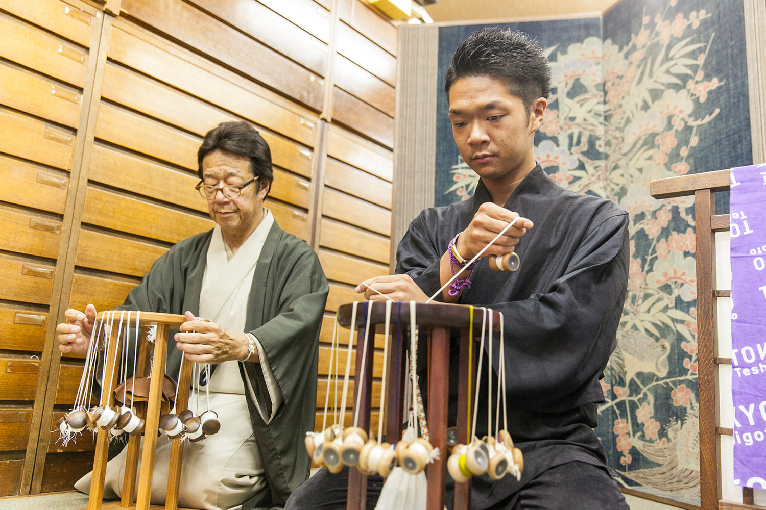 親子の職人が組紐を組む様子
